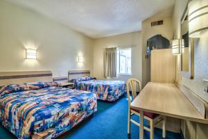a hotel room with two beds and a table at Columbia - Fort Jackson in Columbia