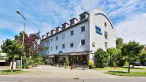 ein großes weißes Gebäude in einer Stadtstraße in der Unterkunft Hotel Maurer in Karlsruhe