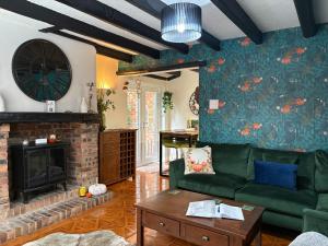 ein Wohnzimmer mit einer grünen Couch und einem Kamin in der Unterkunft On Yarm High Street Great for Couples Families and Business Travel in Yarm