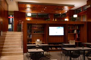 a restaurant with tables and chairs and a television at Hotel Dom Carlos Liberty in Lisbon