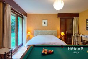 1 dormitorio con cama y mesa de billar en Villa Les Chabannes Pool Billiards & Leisure, en Feytiat