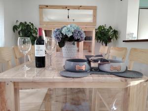 a table with two bowls and a bottle of wine at Casa TioPito in Vadocondes