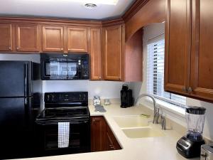 a kitchen with wooden cabinets and a black appliance at Lovely 2 bedroom condo with pool J3 in Little River
