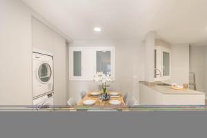 uma cozinha branca com uma mesa de jantar em Espacioso apartamento en el corazón de Pamplona em Pamplona mais 40 fotografias