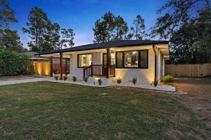 una piccola casa bianca con portico e cortile di New 5 Star Luxury Putting Green Hot Tub EV Fire Pit 5Min From The Masters ad Augusta