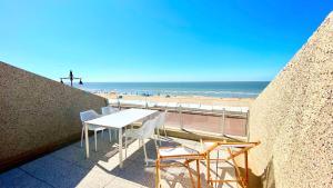 a table and chairs on a balcony overlooking the beach at Seanest - North Sea Stays in De Haan