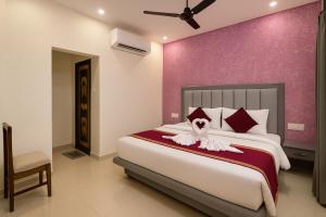 a bedroom with a large bed with a purple wall at IQ Hotels - Luxury Stay Near Ram Mandir in Ayodhya