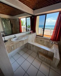 ein Bad mit einem Waschbecken und Blick auf den Strand in der Unterkunft Hermoso loft frente al mar vista increíble in Cancún
