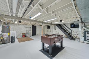 a ping pong table in a room with a staircase at St, Louis Retreat with Game Room & Yard home in Mattese