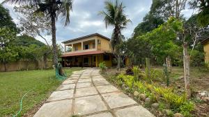 a yellow house with a path in front of it at 4 bed rooms Country House- Giu Camacho in Batelão