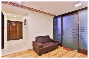 a brown leather chair in a room with glass doors at Hotel Shree Ganapati - Near APJ Kalam Park - Luxury And Spacious Room - Fully Air Conditioned Rooms- Best Hotel Bhubneshwar in Cuttack