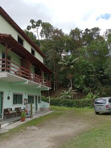 a house with a car parked in front of it at Estúdio Raiz da Mata in Nova Friburgo
