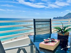 a table with a pair of glasses and a book at Sunrise Atic Altea Beach by DelucaCo in Altea