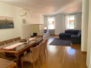 a living room with a dining table and a couch at La Maison V in Pontebba