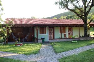ein kleines Haus mit rotem Dach in der Unterkunft Pousada Viajantes do Tempo in Cunha