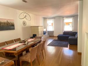 ein Wohnzimmer mit Tisch und Couch in der Unterkunft La maison V in Pontebba