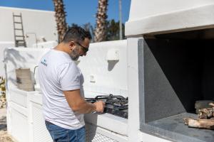un hombre está poniendo algo en un horno en Villa Panacea, en Gallipoli