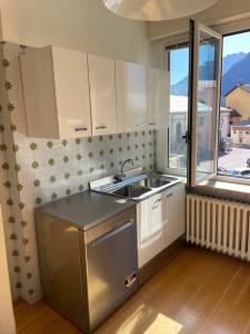 eine kleine Küche mit Spüle und Fenster in der Unterkunft La maison V in Pontebba + 12 Fotos