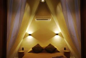 a bedroom with a bed with two pillows and a ceiling at Villa Privada Merkaba Pxm in Brisas de Zicatela
