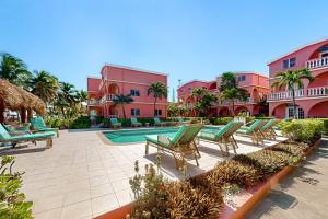a row of chaise lounge chairs next to a resort at Hibiscus @ Caribe Island in San Pedro