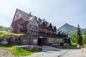 a large building with a mountain in the background at Abuhardillado con preciosas vistas in Cerler