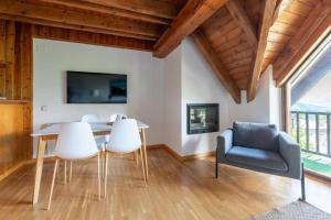a dining room with a table and chairs and a tv at Las casitas de mache - 5F in Cerler