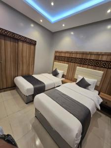 a bedroom with two beds and a blue ceiling at شقق المطار in Jeddah