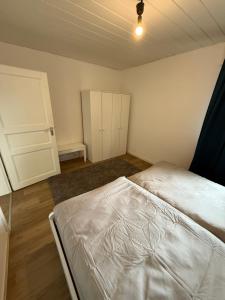 1 dormitorio con cama blanca y armario en Heppenheim Monteurswohnung, en Heppenheim an der Bergstrasse