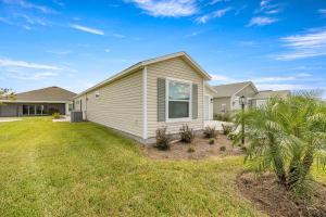 a house with a lawn in front of it at Spacious 2BR in The Villages With Golf Cart and King Bed in Sumterville