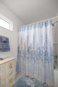 a bathroom with a shower curtain and a tub at Spacious 2BR in The Villages With Golf Cart and King Bed in Sumterville