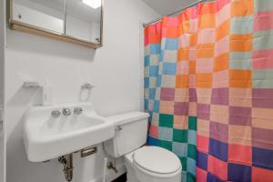 a bathroom with a sink and a colorful shower curtain at House Under The Cliff in New Paltz +18 photos