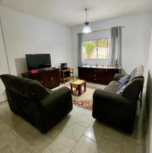 a living room with two couches and a television at Chácara do Paulinho in São Roque