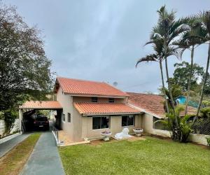 a house with a car parked in front of it at Chácara do Paulinho in São Roque
