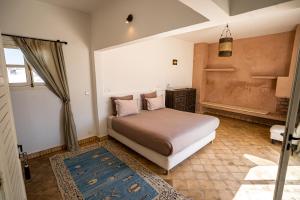 una camera da letto con un letto e una finestra di Riad Bacha Mogador - 5 Suites - Petit Déjeuner a Essaouira