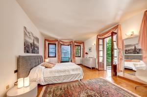 a bedroom with a bed and a large window at Villa Il Cigno Lakeside in Oliveto Lario