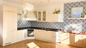 a kitchen with white cabinets and a patterned wall at ART room with rooftop dinner or breakfast in České Budějovice