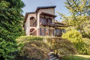 a large house with bushes in front of it at Villa Il Cigno Lakeside in Oliveto Lario