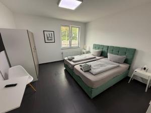 a bedroom with a bed with a green headboard at Aparthotel Siegen in Siegen