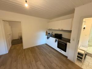 cocina con armarios blancos y suelo de madera en Heppenheim Monteurswohnung, en Heppenheim an der Bergstrasse 4 fotos más