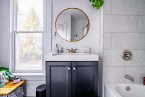 un baño con lavabo y espejo en Short North Convention King Bed Free Parking!, en Columbus