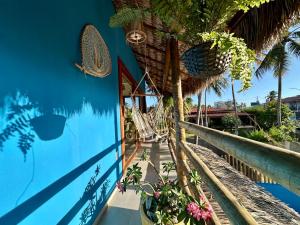 Un resort con una pared azul con una hamaca y palmeras. en Casa maléa, en Amontada
