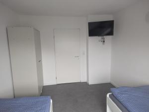 a bedroom with white closets and a flat screen tv at Monteurzimmer A Simon Haus 87 in Jülich