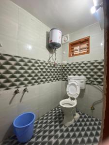 a bathroom with a toilet and a bucket at Gautam Ashiyana Home stay in KumhÄrsain +10 photos