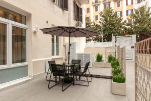 a patio with a table and chairs and an umbrella at Casa Foligno by Hili in Rome