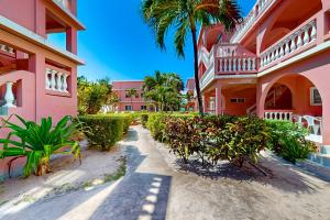 a building with palm trees and plants in front of it at Hibiscus @ Caribe Island in San Pedro