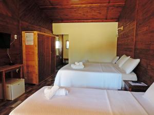 zwei Betten in einem Zimmer mit Holzwänden in der Unterkunft Pousada Viajantes do Tempo in Cunha + 161 Fotos