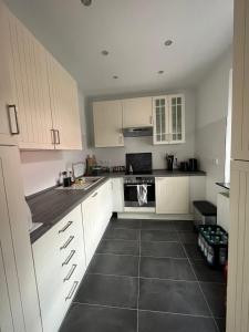a kitchen with white cabinets and a black tile floor at Sunshine in Groß-Zimmern