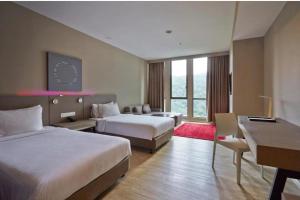 Una habitación de hotel con dos camas y un escritorio. en QQQ hotel type room Empire Damansara, en Petaling Jaya