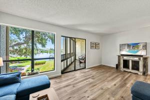 a living room with a couch and a fireplace at Coastal Condo, Water Views, Fishing Dock & 0.6 Miles to Siesta Beach in Siesta Key