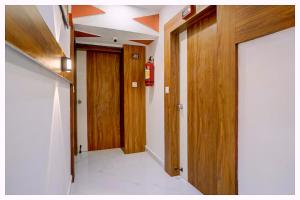 un couloir avec des portes en bois dans une pièce dans l'établissement Hotel Swastik Dham Palace Near Near APJ Kalam Park - Luxury And Spacious Room - Fully Air Conditioned Rooms- Best Hotel Bhubneshwar, à Cuttack